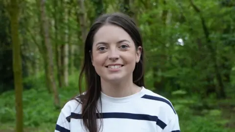 6ab1c1f0-2e93-11f0-ae63-a53f4593c313 6ab1c1f0-2e93-11f0-ae63-a53f4593c313 BBC Kathryn is stood in a wooded area, she is wearing a white striped jumper and has long, dark hair. My bowel had to be removed after years of constipation 6ab1c1f0 2e93 11f0 ae63 a53f4593c313
