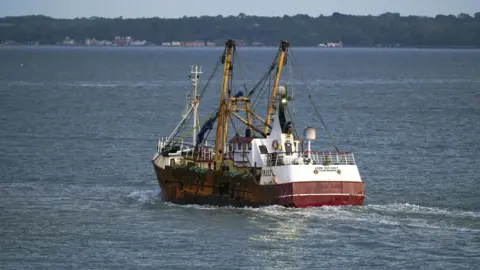 7cc8fdf0-3243-11f0-8947-7d6241f9fce9 7cc8fdf0-3243-11f0-8947-7d6241f9fce9 PA A fishing trawler heading out to sea. Homes can be seen dotted along the shoreline in the distance. Defence deals and palace invites: UK and EU haggle before first summit since Brexit Defence deals and palace invites: UK and EU haggle before first summit since Brexit 7cc8fdf0 3243 11f0 8947 7d6241f9fce9