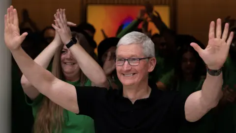 7d9bc1f0-30bc-11f0-9228-d36f84fd1370 7d9bc1f0-30bc-11f0-9228-d36f84fd1370 Reuters Apple CEO Tim Cook in a black t-shirt gestures with both hands during the inauguration of an Apple retail store in New Delhi, India, April 20, 2023 Apple boosts India's factory hopes - but a US-China deal could derail plans Apple boosts India's factory hopes – but a US-China deal could derail plans 7d9bc1f0 30bc 11f0 9228 d36f84fd1370