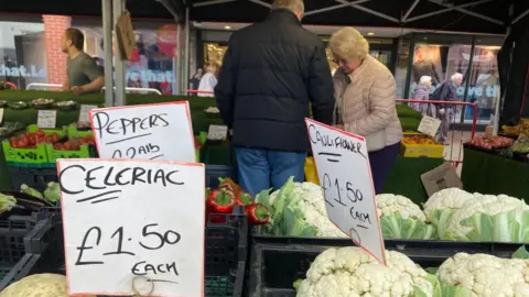 7e93c3b0-241d-11f0-a5a8-bd6ffba156c1 7e93c3b0-241d-11f0-a5a8-bd6ffba156c1 BBC Signs showing prices on a fruit and veg stall, including £1.50 each for celeriac, with a couple shopping in the background. shops could be forced to accept cash in future, mps warn Shops could be forced to accept cash in future, MPs warn 7e93c3b0 241d 11f0 a5a8 bd6ffba156c1