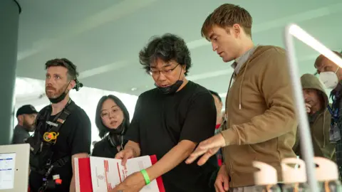 e7738360-29d7-11f0-ad31-9181b2eaffe8 e7738360-29d7-11f0-ad31-9181b2eaffe8 Alamy Bong Joon Ho and Robert Pattinson speak to one another as one of them holds a sheet of paper while they film Mickey 17. trump film tariffs to be part of uk-us trade talks Trump film tariffs to be part of UK-US trade talks e7738360 29d7 11f0 ad31 9181b2eaffe8