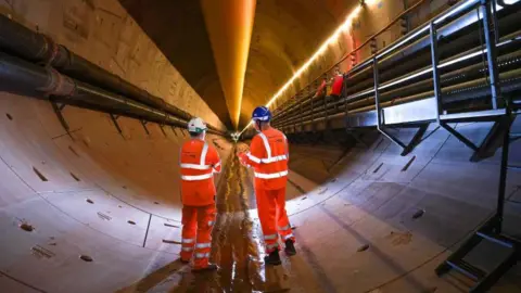 0430c4a0-4bc9-11f0-ac36-b3c74cb34605 0430c4a0-4bc9-11f0-ac36-b3c74cb34605 Getty Images Mining engineers pose as they inspect the progress of the Mary Ann tunnel boring machine (TBM) in the HS2 Bromford Tunnel on September 17, 2024 in Water Orton, England. Opening of HS2 line set to be delayed beyond 2033 0430c4a0 4bc9 11f0 ac36 b3c74cb34605