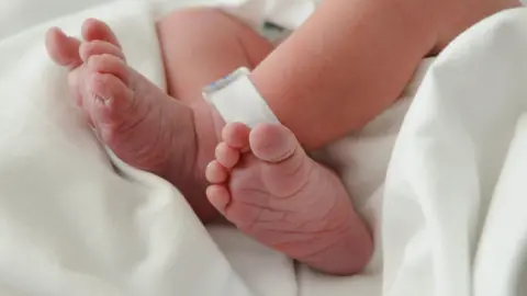 0441b110-4d28-11f0-9efb-9fc6c4760a4c 0441b110-4d28-11f0-9efb-9fc6c4760a4c Getty Images Picture of a newborn baby's naked feet, which are crossed at the ankle. There is a plastic identification tag on one ankle and is laying on a white cotton sheet. Leeds maternity units downgraded to 'inadequate' 0441b110 4d28 11f0 9efb 9fc6c4760a4c