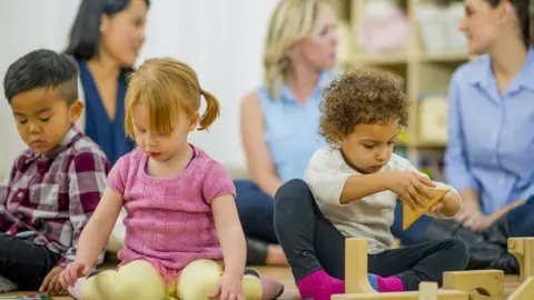 2879c070-3493-11f0-96c3-cf669419a2b0 2879c070-3493-11f0-96c3-cf669419a2b0 Getty Images Three young children sit on the floor playing with toys in a library, with their mothers sitting behind. How can working parents get 15 and 30 hours of free childcare? 2879c070 3493 11f0 96c3 cf669419a2b0
