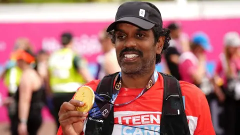 4d825460-3d6a-11f0-bace-e1270fc31f5e 4d825460-3d6a-11f0-bace-e1270fc31f5e PA Media A picture of Romesh Ranganathan holding up his medal at the London Marathon finish line Ranganathan opens up about mental health struggle 4d825460 3d6a 11f0 bace e1270fc31f5e