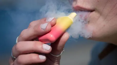 7d59f910-54ce-11f0-bbb4-7b9a23219fce 7d59f910-54ce-11f0-bbb4-7b9a23219fce Getty Images A woman holds a yellow and red coloured vape to her mouth with a cloud of vapour surrounding it. Emma is doing something she swore she never would – buying her kids vapes 7d59f910 54ce 11f0 bbb4 7b9a23219fce