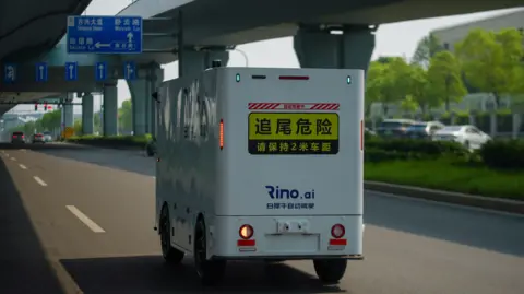 bfb89010-41c2-11f0-bace-e1270fc31f5e bfb89010-41c2-11f0-bace-e1270fc31f5e BBC/Joyce Liu A Rino AI delivery truck cruises on the road in China On board the driverless lorries hoping to transform China's transport industry bfb89010 41c2 11f0 bace e1270fc31f5e