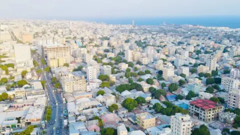 e12ed1a0-46cc-11f0-bbaa-4bc03e0665b7 e12ed1a0-46cc-11f0-bbaa-4bc03e0665b7 Mohamud Abdisamad / BBC A view from up high of Mogadishu showing a main road and lots of new multi-storey buildings and the sea seen on the horizon The women at the centre of Somalia's construction boom e12ed1a0 46cc 11f0 bbaa 4bc03e0665b7