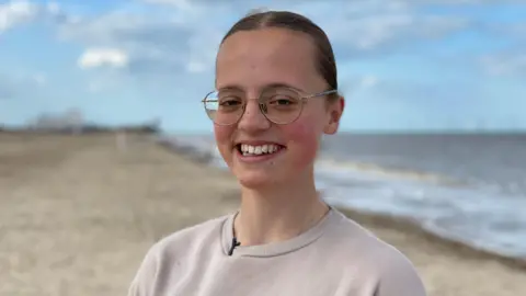 e52fdd60-5286-11f0-9385-f3e2004ea3ca e52fdd60-5286-11f0-9385-f3e2004ea3ca BBC Mary Catchpole, smiling with her hair tied back and wearing glasses. She is standing on a beach near her home in Norfolk Drug for rare disease brings 'joy and hope' e52fdd60 5286 11f0 9385 f3e2004ea3ca