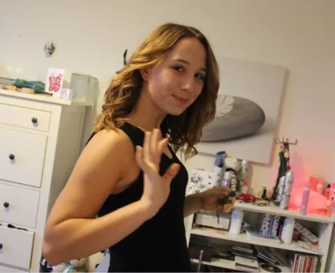 ff8ee890-2a63-11f0-b26b-ab62c890638b ff8ee890-2a63-11f0-b26b-ab62c890638b Family handout Alice is standing in her bedroom on her 18th birthday. She is wearing a black sleeveless dress and is holding her hand up as if she is waving. There is a shelf and chest of drawers behind her and an artwork on the wall. We quit our jobs, sold our home twice and spent 10 years fighting for the truth ff8ee890 2a63 11f0 b26b ab62c890638b