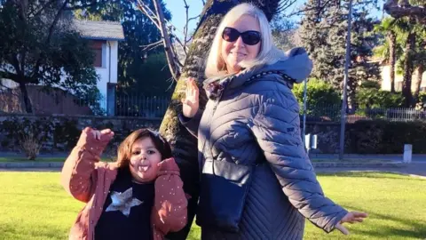 Chiara Del Vescovo Chiara Del Vescovo and her daughter hold their arms out as they pose next to a tree in a park  Summer holiday club costs: &#039;It&#039;s the amount you&#039;d spend going away&#039; 002ebff0 6268 11f0 b903 f515e3045d80