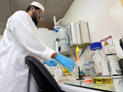 017c0e40-5cc7-11f0-a40e-a1af2950b220 017c0e40-5cc7-11f0-a40e-a1af2950b220 Prof Abdullah Ely is in his lab, in a white coat and blue gloves The US helped successfully tackle Aids – now cuts put that at risk 017c0e40 5cc7 11f0 a40e a1af2950b220
