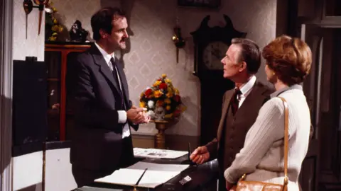 0db1e1b0-581e-11f0-988d-abc8933015ea 0db1e1b0-581e-11f0-988d-abc8933015ea John Cleese as Basil Fawlty with Basil Henson as Doctor Abbott and Elspet Gray as Mrs Abbott in a still from Fawlty Towers. British Bulldogs to mobile phones – your banknote redesign ideas 0db1e1b0 581e 11f0 988d abc8933015ea