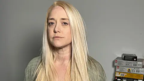 14e588c0-5cd2-11f0-bf1d-8d27518e9506 14e588c0-5cd2-11f0-bf1d-8d27518e9506 Sheryl Hunter, a middle aged woman with long blonde hair, looks directly into the camera. She wears a green/grey cardigan. Surgeon banned by private practice is working for NHS 14e588c0 5cd2 11f0 bf1d 8d27518e9506