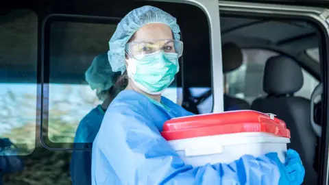 4a4ec510-5d92-11f0-9297-dd87eb704fa9 4a4ec510-5d92-11f0-9297-dd87eb704fa9 Getty Images a female medic wearing blue scrubs and a face mask holds an organ transplant container, which is a white plastic tub with a red lid. She appears to be stood to the side of a vehicle with a sliding door 'Both my daughters needed new hearts' 4a4ec510 5d92 11f0 9297 dd87eb704fa9