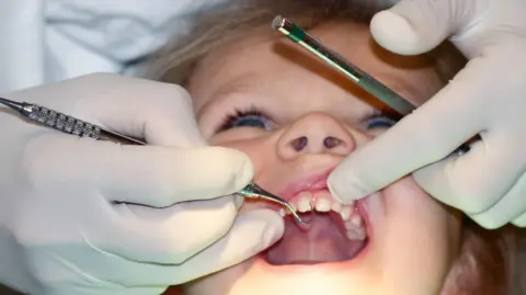 50d7a010-5828-11f0-988d-abc8933015ea 50d7a010-5828-11f0-988d-abc8933015ea Getty Images Young child at dentist's with mouth wide open, close up dentist's hands using implements to examine the child's teeth. Seven ways Starmer's plan could change the NHS 50d7a010 5828 11f0 988d abc8933015ea