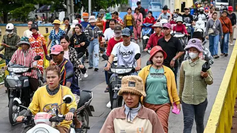 be952300-5d7f-11f0-a6b8-21ace6496903 be952300-5d7f-11f0-a6b8-21ace6496903 Getty Images Garment workers, men and women, walk out in a large group from their factory during their lunch break in Phnom Penh on July 8, 2025. Asia is reeling from Trump's tariff salvo – is anyone winning? be952300 5d7f 11f0 a6b8 21ace6496903