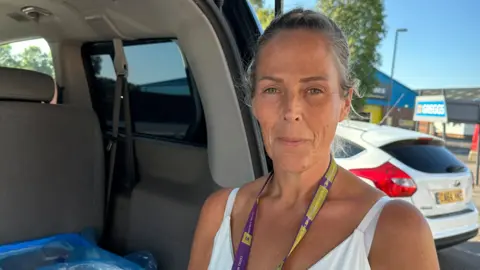 BBC A woman in a white vest standing at the open boot of a van in a car park looking at the camera  &#039;It&#039;s heartbreaking leaving women sleeping rough&#039; d3880720 5bde 11f0 960d e9f1088a89fe