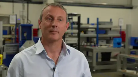 Mick Crosthwaite stands in a factory wearing a grey shirt.  Reeves disappointed after economy unexpectedly shrinks de3c5730 5e26 11f0 bbf2 09f80948283f