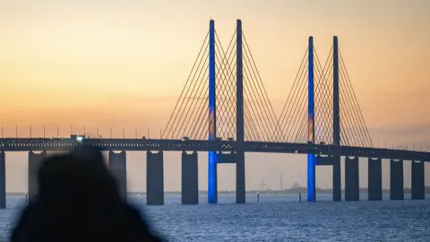 f30c4ba0-5261-11f0-8485-7bd50fa63665 f30c4ba0-5261-11f0-8485-7bd50fa63665 Getty Images The Oresund Bridge lit up with the Swedish flag The bridge changing lives and boosting business f30c4ba0 5261 11f0 8485 7bd50fa63665